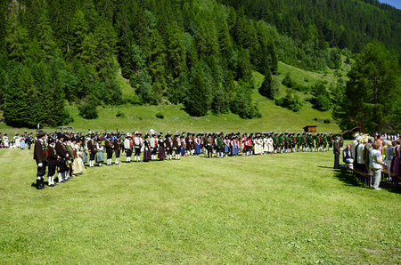 Feichten, Tyrol, Austria - June 22, 2014: Unidentified people in traditional outfit in Dirndl and Lederhose by field mass in Kaunertal valleyのeditorial素材