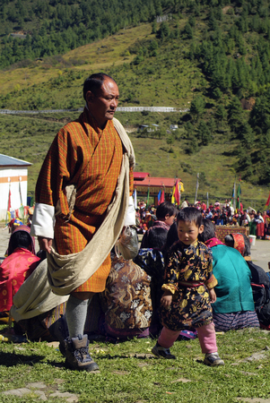 Haa, Bhutan - September 21, 2007: Unidenified man with child in traditional clothes named Gho with Kabneyのeditorial素材