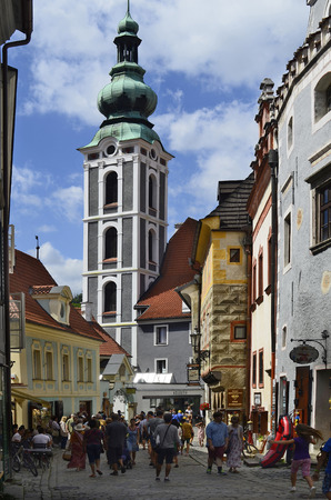 Cesky Krumlov, Czech Republic - August 11, 2013: Unidentified tourists in a small street with different shops, house with sgraffito decorated facade and St. Jost church in the Unesco World Heritage site in Bohemiaのeditorial素材