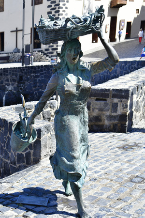 Tenerife, Canary Islands, Spain - April 03, 2018: Bronze sculpture of a fishmonger from sculptor Julio Neto  in Puerto de la Cruzのeditorial素材