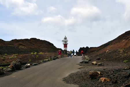 Tenerife, Canary Islands, Spain - April 04, 2018: Unidentified people on lava rocks to lighthouse Faro de Tenoのeditorial素材