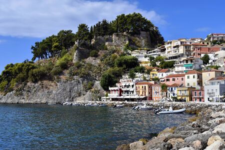 Parga, Greece - September 21, 2019: Colorful townscape with ruin of medieval castle located on...