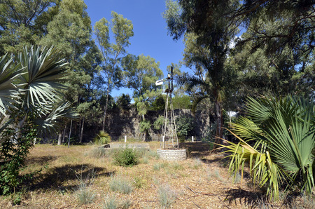 Greece, Epirus, public park with well and wind wheel in front of the medieval castle in Preveza