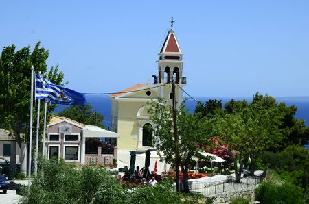 Zakynthos, Greece - May 26, 2016: Greece, Zakynthos Island, church Zoodochos Pigi and different flags over Zakynthos townのeditorial素材