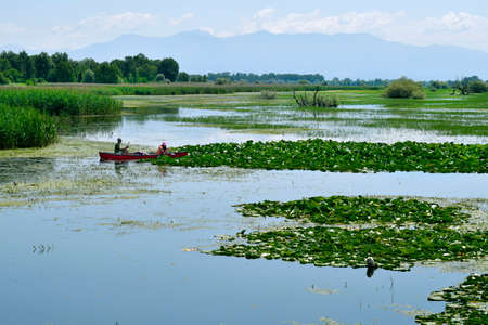 Livadia, Greece - June 21, 2021: Two unidentified people in canoe on Lake Kerkini in Central Macedonia, a favorite spot for water birdsのeditorial素材