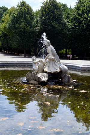 Vienna, Austria - August 01, 2022: Unidentified people rest on bench at western naiad fountain in a rondeau along the tree-lined avenues in the park of former residence of the Habsburg rulers and today a UNESCO World Heritage Site, world-famous tourist atのeditorial素材