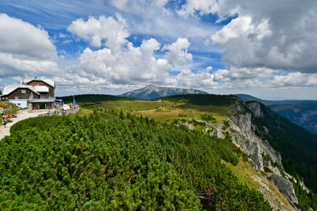 Hirschwang, Austria - August 10, 2022: Unknown hikers take a break at the mountain inn called Ottohaus on Rax mountain in Lower Austria, Schneeberg mountain in background, both are part of the Vienna Alpsのeditorial素材