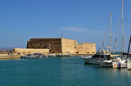 Heraklion, Greece - October 14, 2022: The capital of Crete Island, unidentified people by sightseeing at the small harbor for yachts and fishing boats with the Venetian Fortress Koulesのeditorial素材