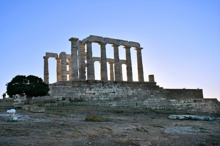 Lavrio, Greece - December 19, 2023: The ancient Temple of Poseidon in the light of the setting sunの写真素材
