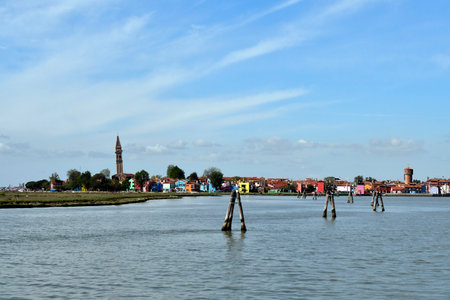 Burano, Italy - View of the colorful houses, the historic water tower and the church Chiesa Parrocchiale di San Martino Vescovo with the leaning steeple on the island of Burano in the Venice lagoonの写真素材