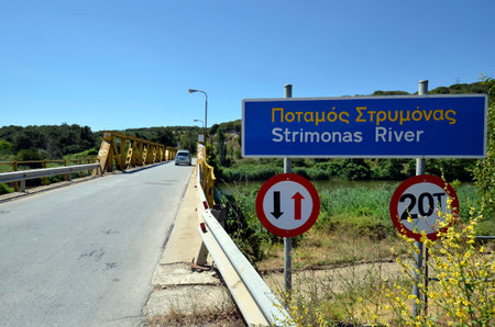 Greece, traffic sign waiting obligation for oncoming traffic and weight restriction on the bridge over the Strimonas riverの写真素材