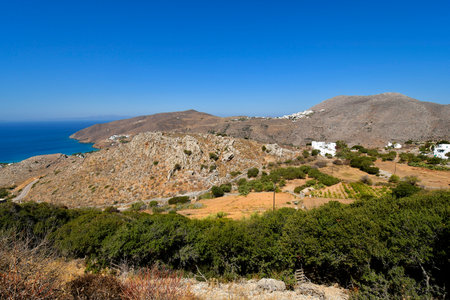 Amorgos, Greece - View from Lagkada over the treeless landscape, partly with traditional stone walls, to the mountain village of Tholaria and the beaches at Aigialis on Aegean Seaの写真素材