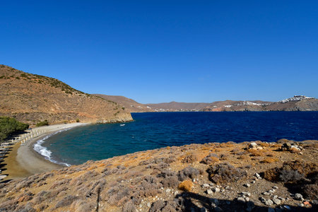 Astypalea, Greece - September 07, 2025: View from Agios Konstantinos beach with parasols and sunbeds to Livadi bay with beach and Chora town on the island in the Aegean Seaの写真素材