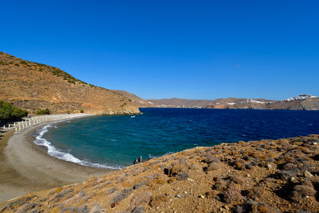 Astypalea, Greece - September 04, 2025: Agios Konstantinos beach with parasols and sunbeds on the island in the Aegean Sea, view to Chora Villageの写真素材