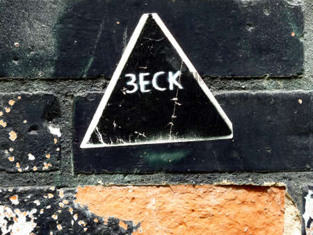 black triangle with white edge on an old black wallの写真素材