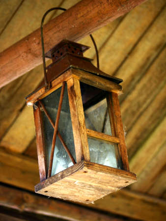 Lantern made of wood to a wooden beamの写真素材