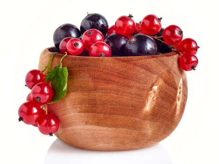 Blackcurrant and redcurrant berries in traditional finnish birch cup, isolated over white background の写真素材