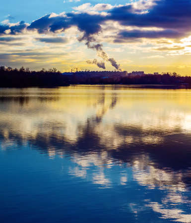 Coal burning power plant with pollution against dark clouds