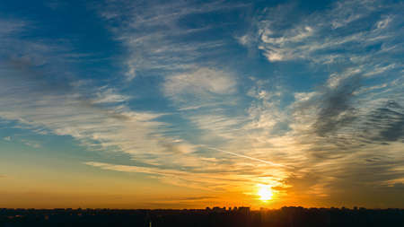 Panorama  Orange sunrise silver cloud over silhouette cityの写真素材
