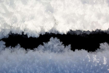 Real snow crystals on a black background lit by the sun in cold weather