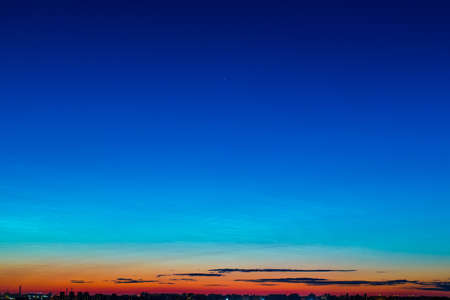 Bright summer night on the town  Multi-colored sky before dawn with a few clouds on the horizon, and the night cityの写真素材