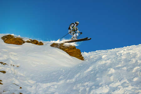 Skier jumps from a cliff during fast motion  Backlight of the sunの写真素材