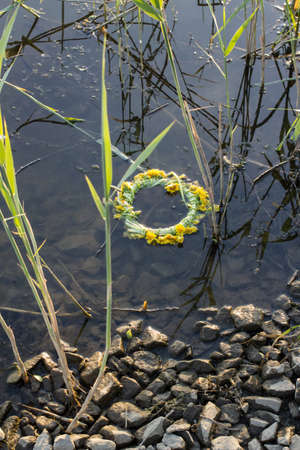 Wreath of dandelions on the surface of the lakeの写真素材