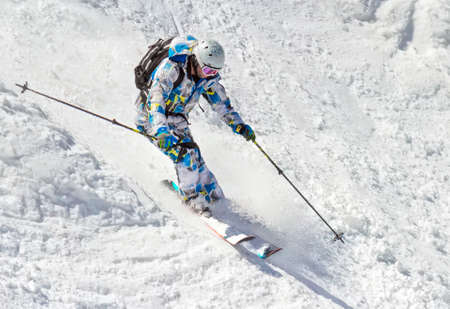 Man skier on a steep slope in the mountainsの写真素材