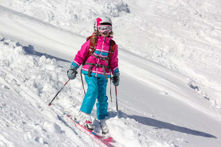 Little girl on skis plastered with snowの写真素材
