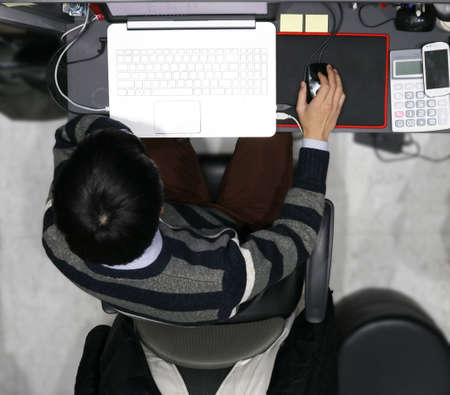 A man struggling to finish work in front of monitor in his officeの写真素材