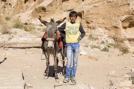 PETRA, JORDAN - December 25th 2015: Arab boy with his donkey in Petra Jordanのeditorial素材