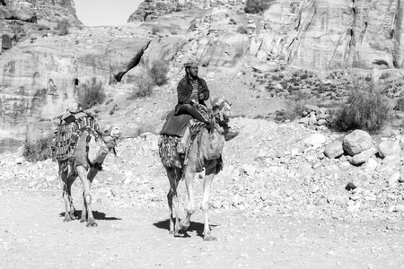 Petra, Jordan - December 25, 2015: Bedouin man riding a camel in the ancient Nabatean city of Petra, Jordanのeditorial素材