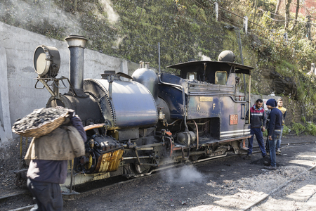 Darjeeling, India, March 3 2017: Heating the steam locomotive and filling the coal bunker of the...