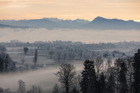 Ice cold winter morning with fog and Mount Rigi in the background at sunrise in Central Switzerlandの写真素材