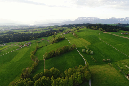 Hills landscape in Central Switzerland in the morning light with Mount Pilatus in the backgroundの写真素材