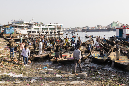 Dhaka, Bangladesh, February 24 2017: Men wait for passengers in their small rowboats at Sadarghat of the Buriganga River in Dhaka Bangladeshのeditorial素材