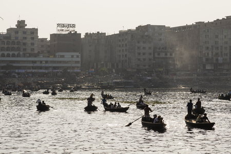 Dhaka, Bangladesh, February 24 2017: Backlit shot of small wooden boats used as a taxi operate on the Buriganga River in Dhaka Bangladeshのeditorial素材