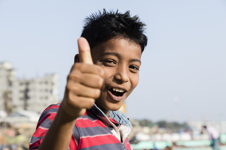 Dhaka, Bangladesh, February 24 2017: Portrait of a young handsome and laughing teenager in Dhaka Bangladesh making thumbs up signのeditorial素材