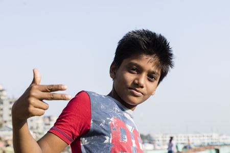 Dhaka, Bangladesh, February 24 2017: Portrait of a young handsome teenager in Dhaka Bangladesh making a cool hand gestureのeditorial素材