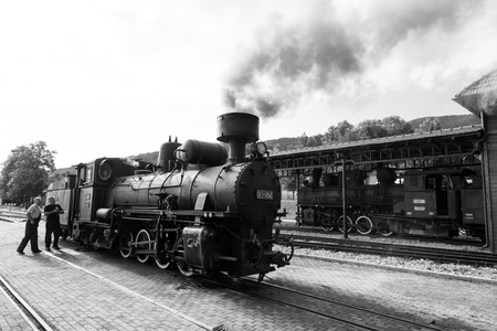 Sargan Vitasi, Serbia, July 17 2017: Two train drivers prepare the steam locomotive for the journey. From here start the so calledのeditorial素材