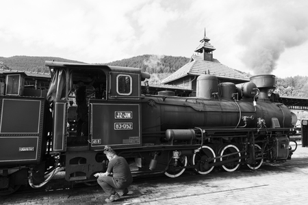 Sargan Vitasi, Serbia, July 17 2017: Locomotive driver washes his hands before leaving. In the background the smoking steam locomotiveのeditorial素材