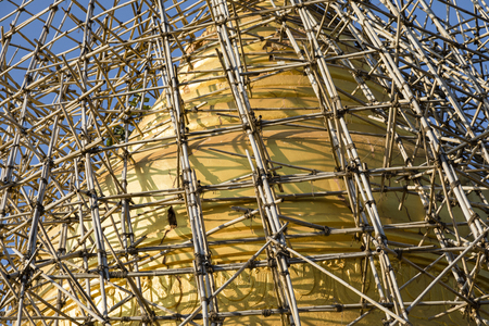 After an earthquake, the damaged, golden stupa of a pagoda in Bagan is scaffolded with bamboo, Myanmarの写真素材