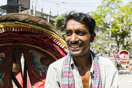 Dhaka, Bangladesh, February 24 2017: Portrait of a smiling Trishaw driver proudly posing next to his vehicle in Dhaka, Bangladeshのeditorial素材