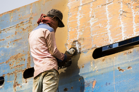 Dhaka, Bangladesh, February 24 2017: Worker on a ship dock on Dhaka Bangladesh grinding a metal plateのeditorial素材