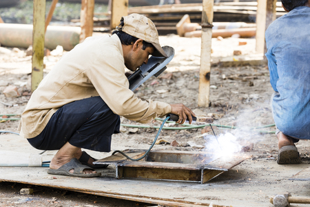 Dhaka, Bangladesh, February 24 2017: Welder on a ship dock on Dhaka Bangladesh welding together two pieces of metalのeditorial素材