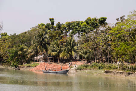 Morrelganj, Bangladesh, February 27 2017: At the riverside in Bangladesh, bricks are being unloaded...