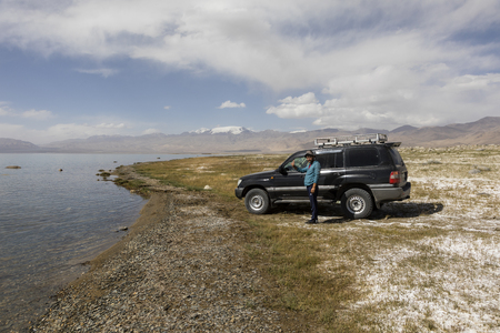 Karakul, Tajikistan, August 22 2018: Car with driver at the Karakul lake near Karakul town in the pamir mountains in Tajikistanのeditorial素材