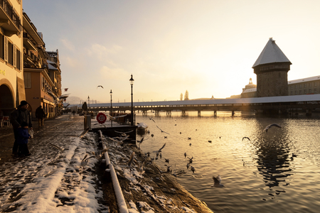 Lucerne, Switzerland, February 4, 2019: Lucerne with snow covered wooden bridge called chapel bridge and water tower with reuss river on a wonderful winter morningのeditorial素材