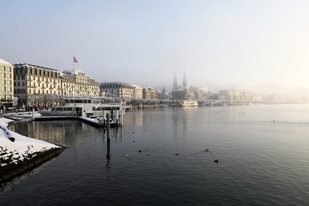 Lucerne, Switzerland, February 4, 2019: Lake Lucerne with pier and church of St. Leodegar on a mystical winter morning in Lucerneのeditorial素材