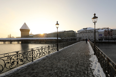 Lucerne, Switzerland, February 4, 2019: Lucerne with snow covered wooden bridge called chapel bridge and water tower with reuss river on a wonderful winter morningのeditorial素材